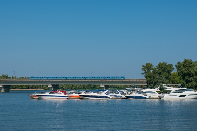 Muelle de barcos de la ciudad, barcos blancos en el río, paisaje de la ciudad