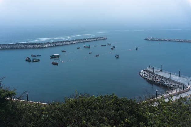 Muelle de Chorrillos en Lima, Perú, varios barcos de pescadores y rompeolas