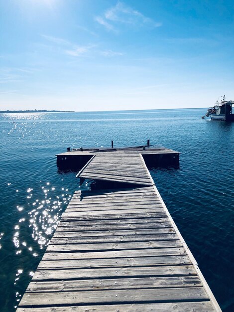 El muelle dañado sobre el mar contra el cielo azul