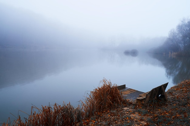 Muelle en el lago de niebla de invierno