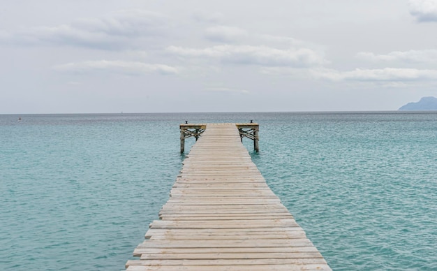 Muelle de madera, aguas tranquilas de color turquesa en el mar Mediterráneo, escenas de vacaciones con una sensación de calma