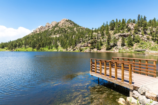 Muelle de madera en el lago contra las Montañas Rocosas