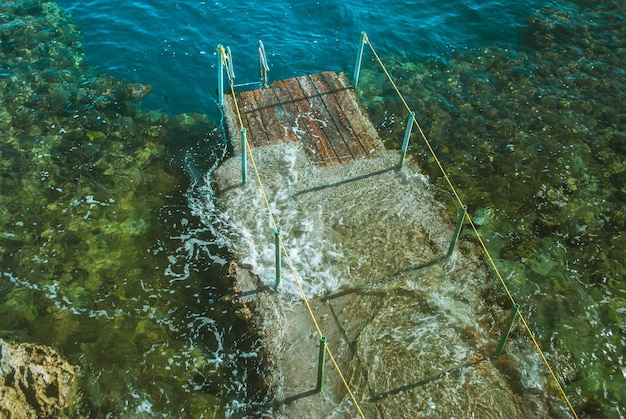 muelle de madera en el mar con olas