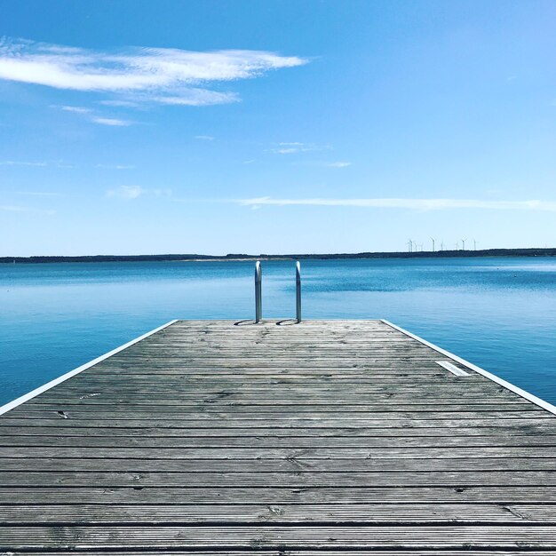 Muelle de madera en la piscina contra el cielo