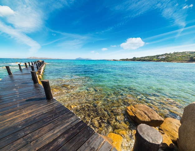 Foto muelle de madera en la playa de romazzino cerdeña