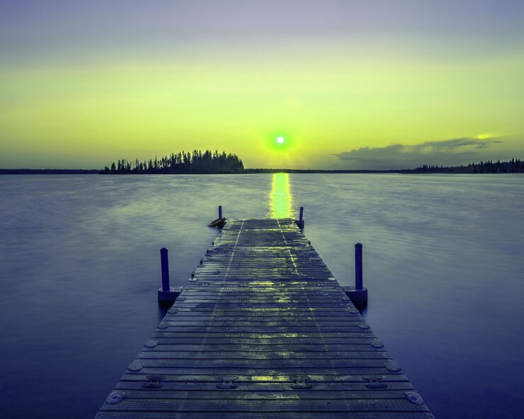 Un muelle de madera vacío en un lago durante una puesta de sol impresionante un fondo fresco