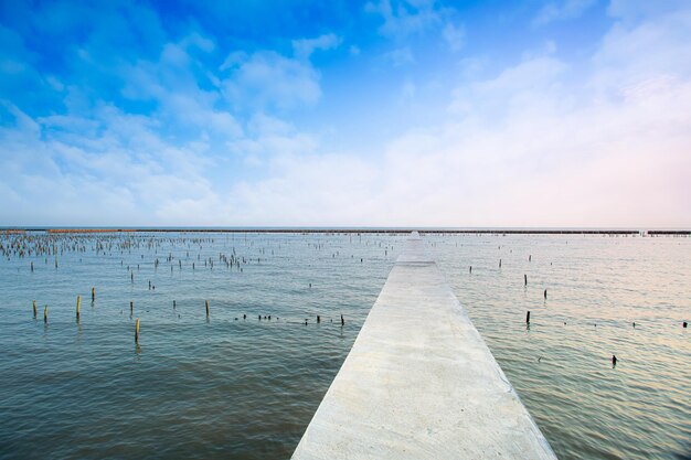 El muelle que se extiende hacia el mar con vista al mar con un cielo nublado