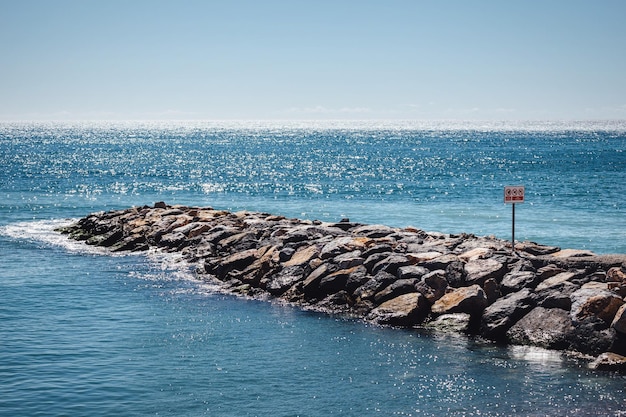 El muelle rocoso en el mar