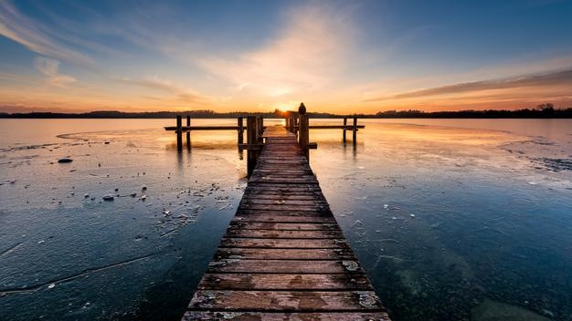 Muelle sobre el mar contra el cielo durante la puesta de sol