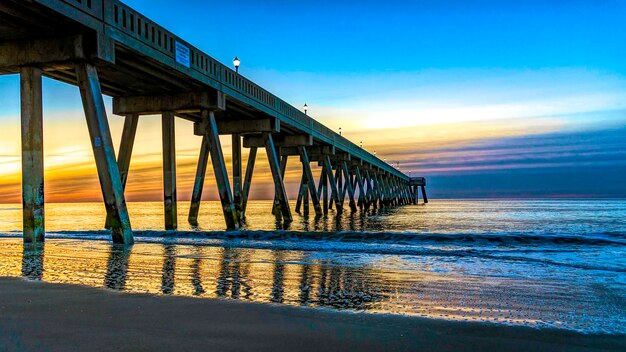 Muelle sobre el mar contra el cielo durante la puesta de sol