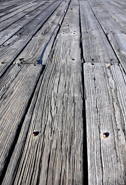 Muelle con tablas de madera desgastadas en bruto en la primavera.