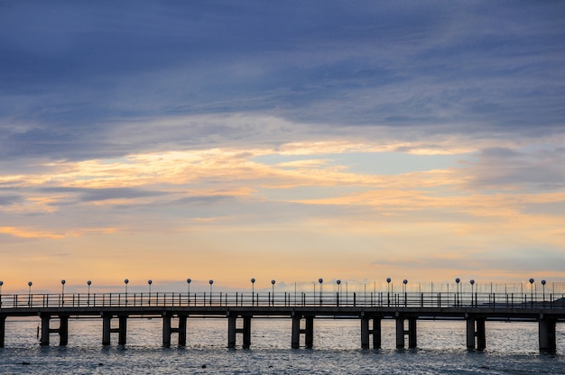 Muelle vacío del mar sin gente al atardecer.