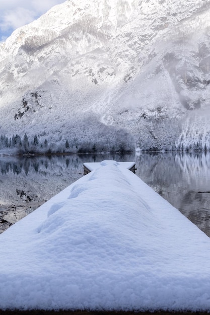 Muelles y reflejo de las montañas y el bosque en el lago de montaña.