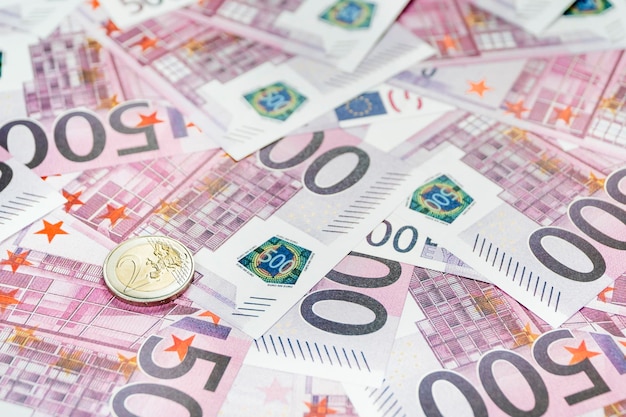 Münze im Wert von zwei Euro auf einem Hintergrund von Papiergeld