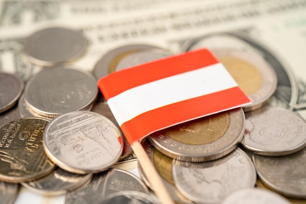 Münzstapel mit österreichischer Flagge auf US-Dollar-Banknote