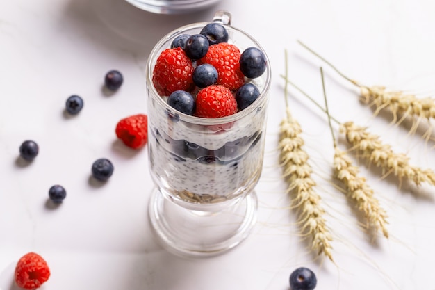 Muesli con bayas y semillas de chia en una mesa de mármol claro