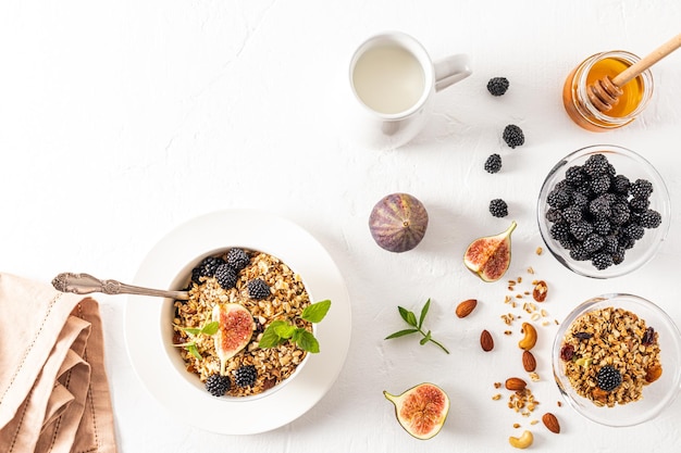 Muesli caseiro de passas de aveia mel amoras e nozes em uma tigela com leite de coco o conceito de um café da manhã saudável