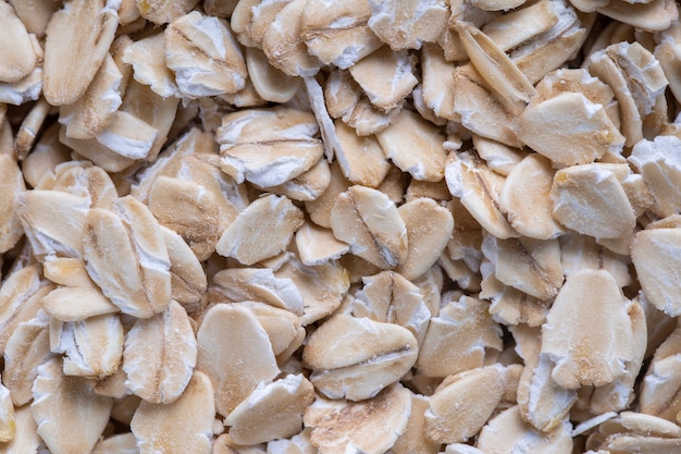 Muesli de cereal dorado, fondo y textura. Granos de avena de cerca, vista superior, macro. Desayuno saludable