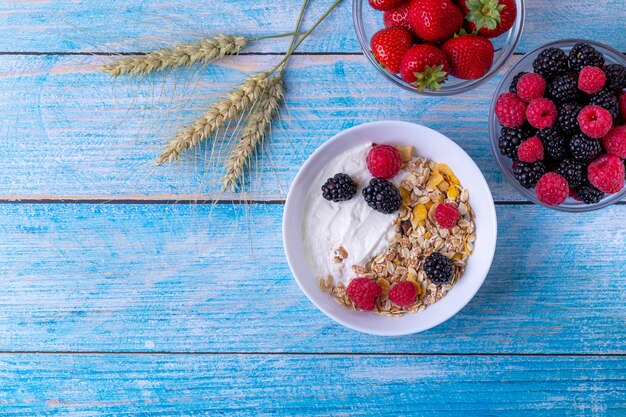 Muesli com iogurte e frutas na mesa de madeira