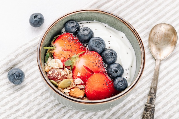 Muesli de aveia com iogurte e frutas frescas em uma tigela para um café da manhã saudável