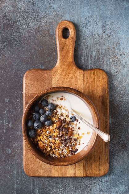 Muesli de granola caseiro com mirtilos em cinza escuro, vista superior vertical