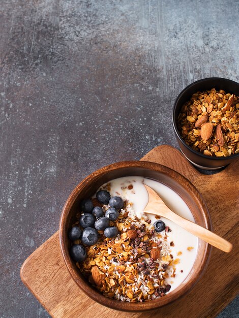 Muesli de granola caseiro com mirtilos em cinza escuro, vista superior vertical