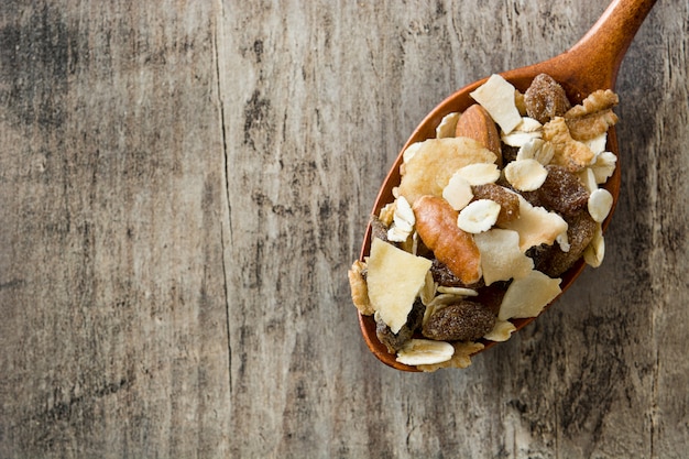 Muesli e frutas secas na colher de pau na mesa de madeira