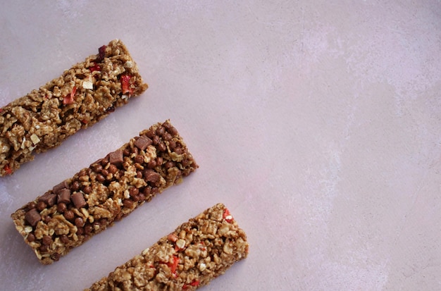 Müsli-Fitness-Riegel mit Beeren auf violettem Hintergrund mit Kopierraum