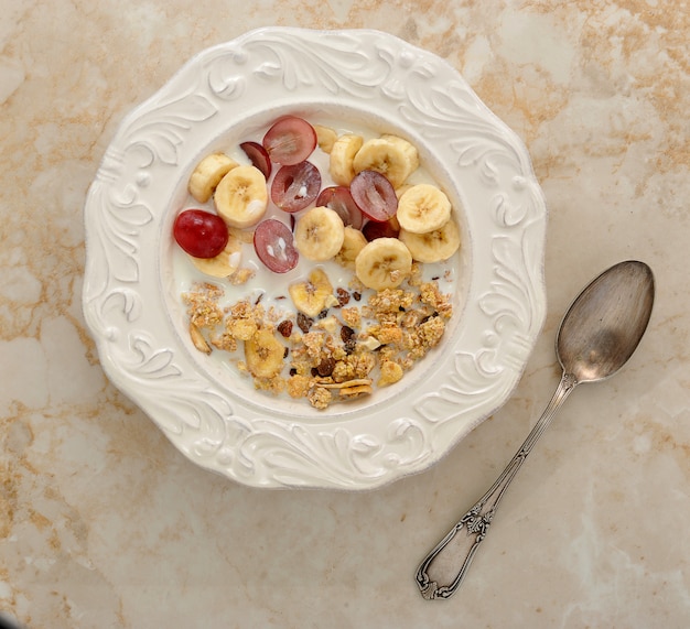 Müsli mit Banane, Trauben und Milch. gesundes Frühstück.