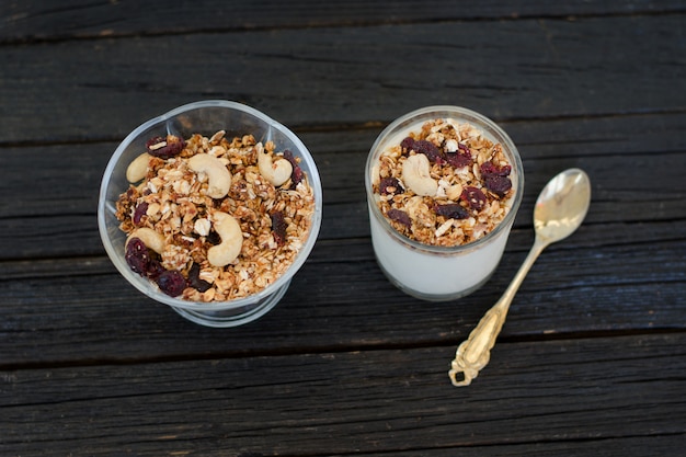 Müsli mit Beeren und Joghurt auf einem schwarzen Holztisch. Traditionelles amerikanisches Frühstück