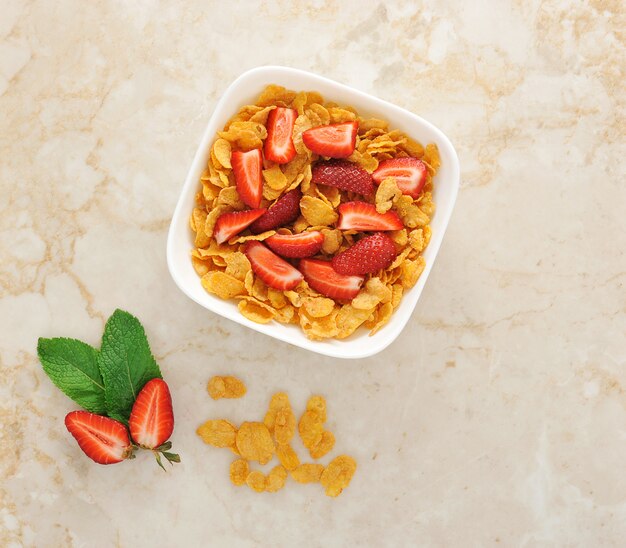 Müsli mit Erdbeeren in Stücke schneiden