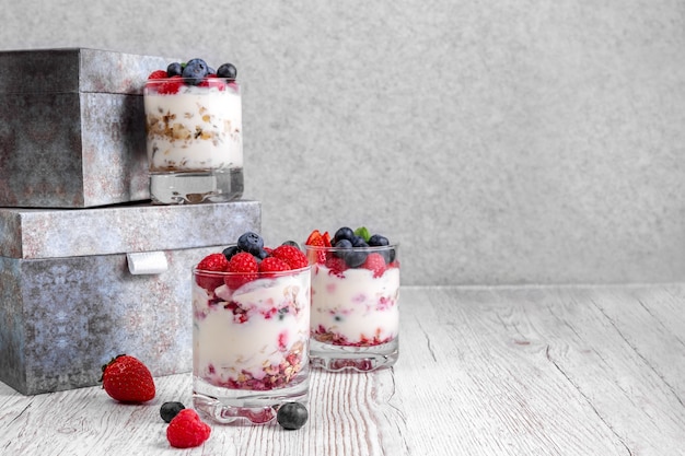 Müsli mit Joghurt und Beeren im Glas auf weißem Hintergrund