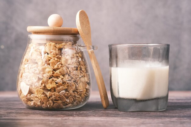 Müsli mit Trockenfrüchten im Glas mit Glas Milch auf dem Tisch