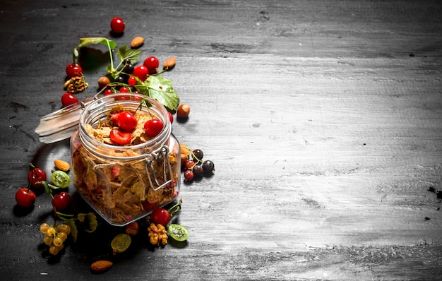 Müsli mit Waldbeeren auf einem schwarzen hölzernen Hintergrund