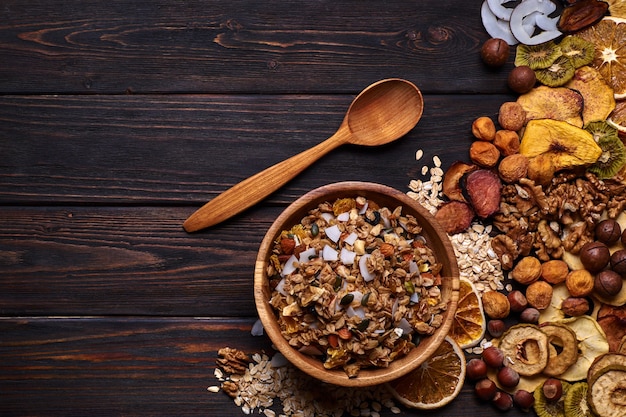 Müsli und getrocknete Früchte mit Nüssen auf einem Holztisch