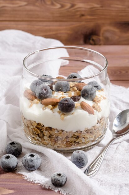 Muesli con yogur natural, arándanos, nueces y frutas secas en un frasco de vidrio
