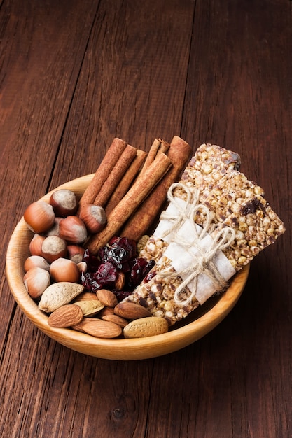 Müsliriegel mit Nüssen, Beeren und Zimt auf einem hölzernen Hintergrund