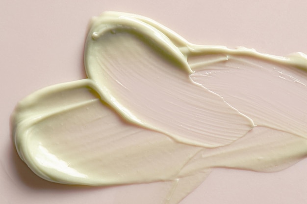 Una muestra de crema hidratante sobre un fondo rosa Producto cosmético para la piel