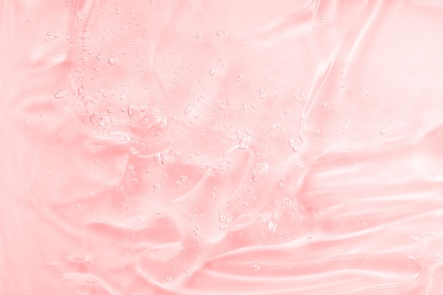 Muestra de textura de suero con colágeno y péptidos gel líquido transparente con fondo de burbujas Muestra de producto de cuidado de la piel de belleza transparente rosa