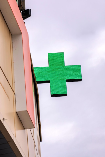 Muestra verde de la farmacia de la cruz en un edificio