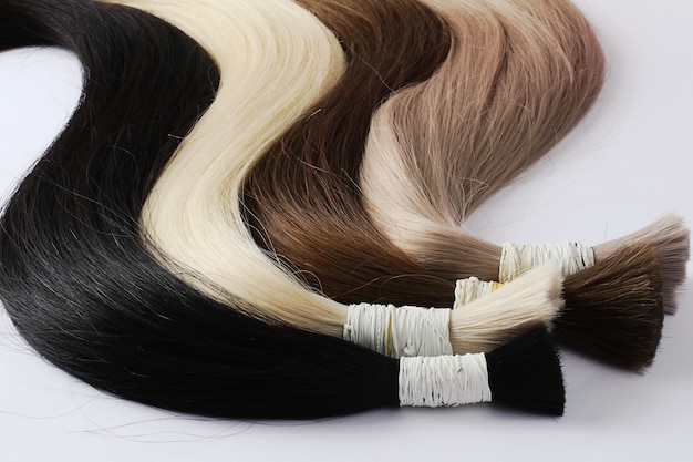 Muestras de cabello para extensiones enrolladasDiferentes coloresFondo blanco