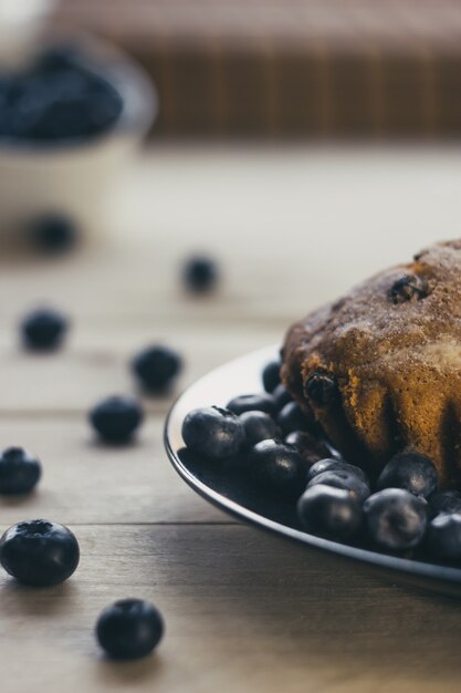 Muffin y arándanos esparcidos sobre la mesa