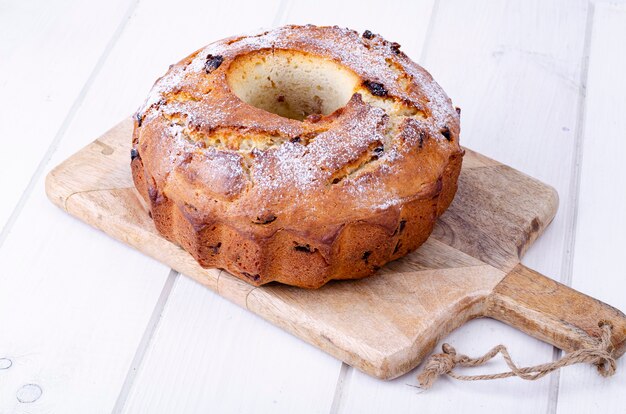 Muffin casero dulce con pasas sobre plancha de madera. Foto de estudio