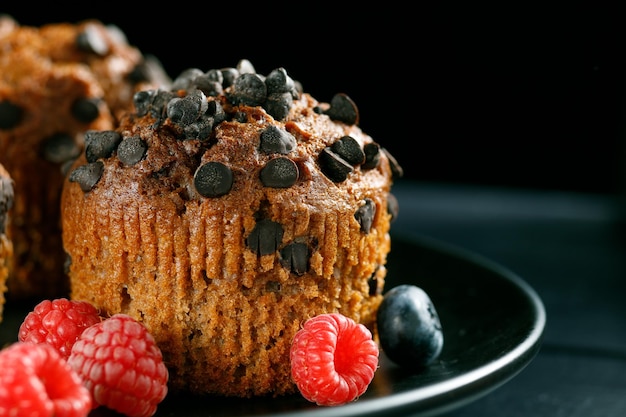 Muffin de chocolate con bayas Apetitosos cupcakes sobre un fondo oscuro