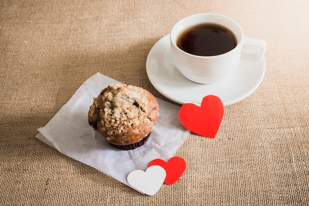 Muffin de chocolate y café y corazones en texturas de cilicio.