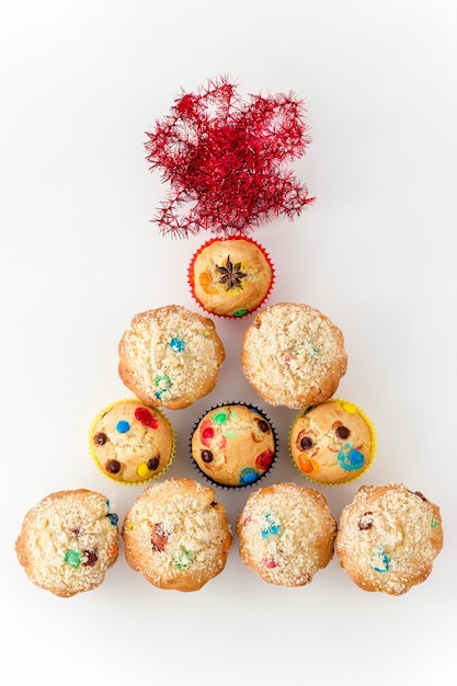 Muffin con chocolate colorido y taza de té negro Fondo festivo dorado con oropel Vista superior