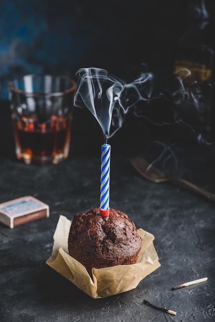 Muffin de chocolate de cumpleaños con vela humeante