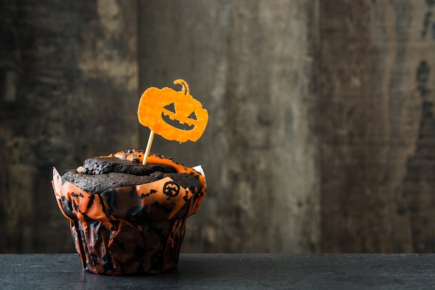 Muffin de chocolate de Halloween en mesa de madera. Copia espacio