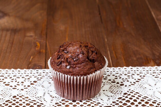 Muffin de chocolate en mesa de madera oscura