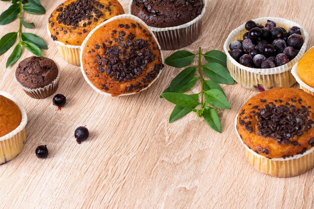 Muffin de chocolate y muffin de nueces, panadería casera sobre fondo oscuro.